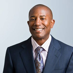 Attractive African American headshot dressed in a suit and tie, facing the camera. Horizontal